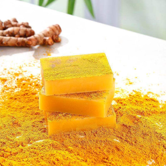 Hardonia turmeric soap for glowing skin stacked on a table with turmeric powder